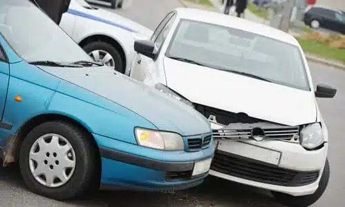 A collision between two vehicles with police presence in the background responding to the accident.