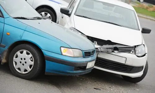 A blue and white car are pictured after a car accident.