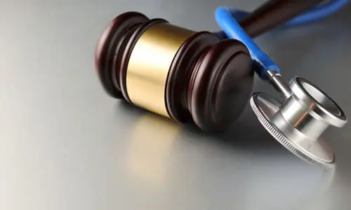 A stethoscope is pictured next to a judge's gavel, medical malpractice concept.