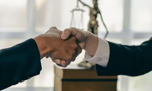 A negligence lawyer shakes hand with a new client.