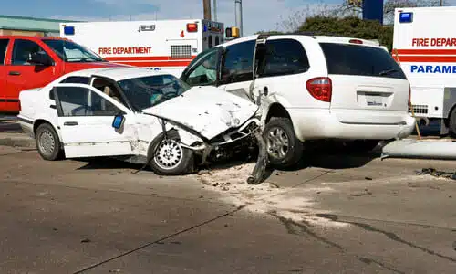 Two white vehicles in the middle of an intersection after an accident.