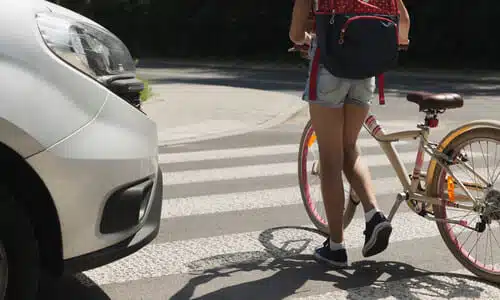 A young cyclist almost having been hit by a car at a pedestrian crossing.