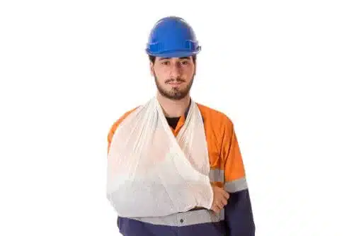 A young injured construction worker with his arm in a sling.