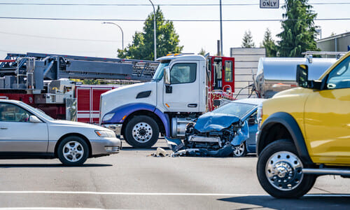 An accident between a car and a fuel truck at a suburban intersection.