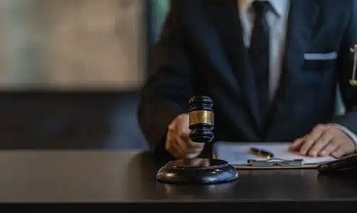 A slip and fall lawyer holding his gavel over a soundblock at his office desk.