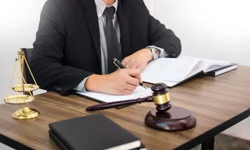 A personal injury lawyer going through notebooks and documents while working on a client's case.
