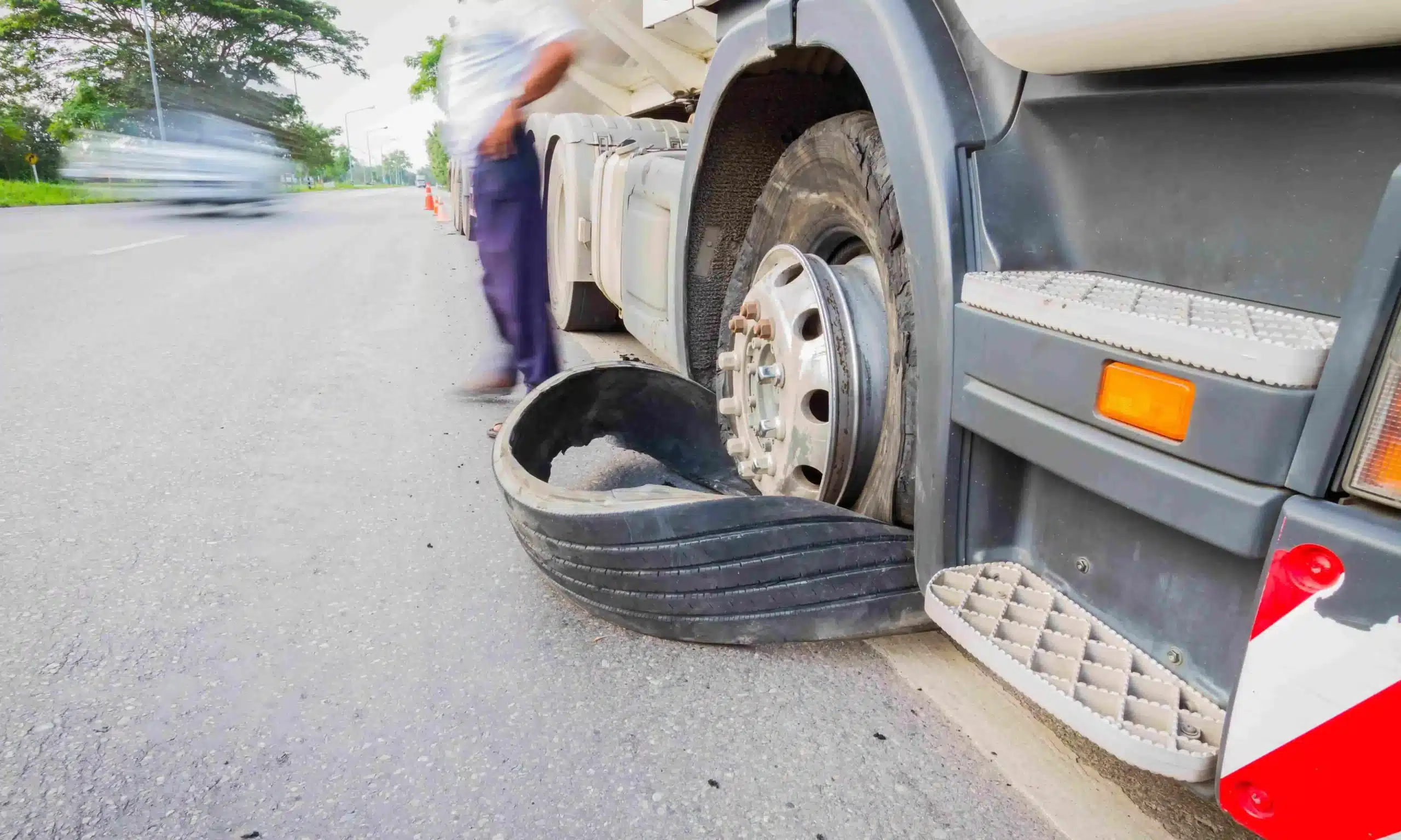 An eighteen-wheel semi truck with a flat tire after an accident on a road.