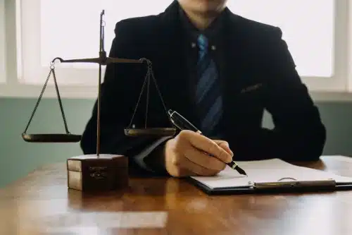 A personal injury lawyer pointing a pen at lines in a client's insurance policy.