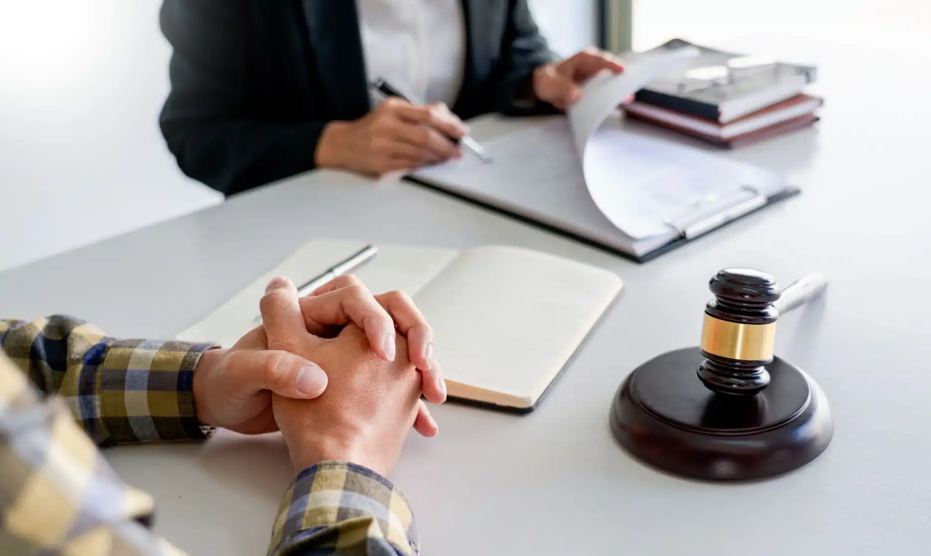 A lawyer together at a desk with a client reviewing terms of an insurance policy.