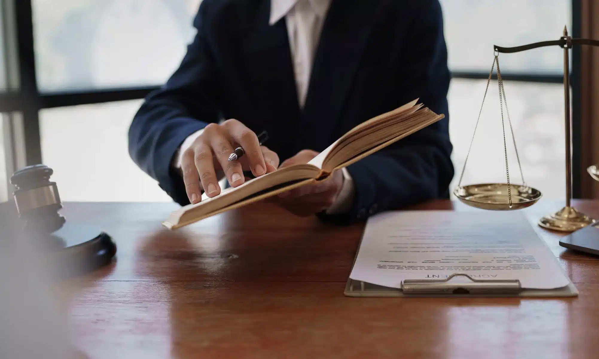 A lawyer holding up a law book and pointing out a line to a client.