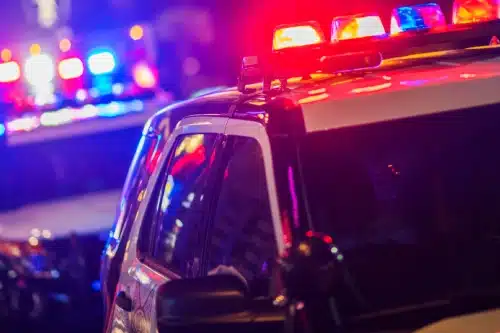 Police vehicles responding to a car accident scene at night.