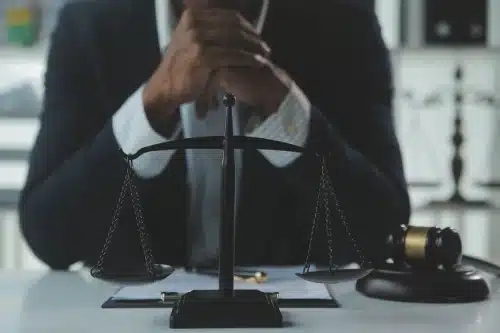 A lawyer in an office clasping his hands while awaiting a client in hhis office.