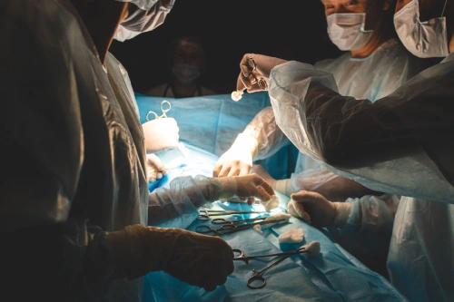 Doctors and nurses performing a procedure on a patient in an operating theater.
