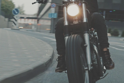 A low shot of a motorcyclist making a turn on a city road in the evening.