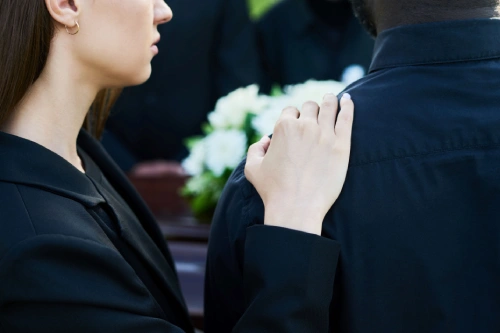 A woman comforting the loved one of a deceased wrongful death victim.