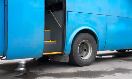 An open door of a blue bus awaiting to be boarded by passengers.