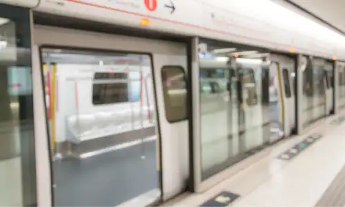 An empty subway car coming to a stop at a station.