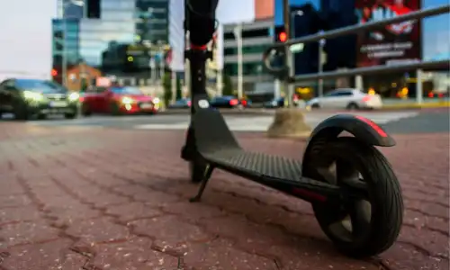 An electric scooter on a cobblestone path in the early evening hours.