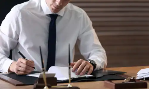 A personal injury lawyer studying a law book and gathering information for a client's case.