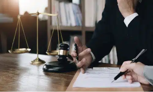 A slip and fall accident lawyer sitting next to a client and discussing a case in an office.