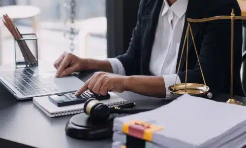 A medical malpractice lawyer verifying notes with research on her laptop.