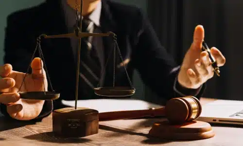 A lawyer holding a pen while his hands are outstretched as he explains details of a case to his client.