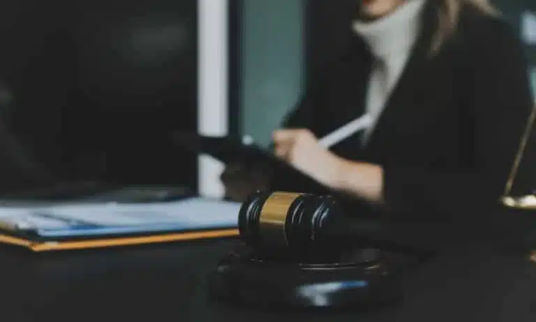 A lawyer taking notes for a case while seated behind her desk.