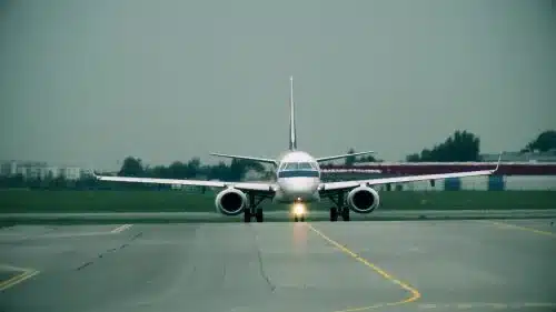 A commercial jet plane taxis on a runway on a cloud day.