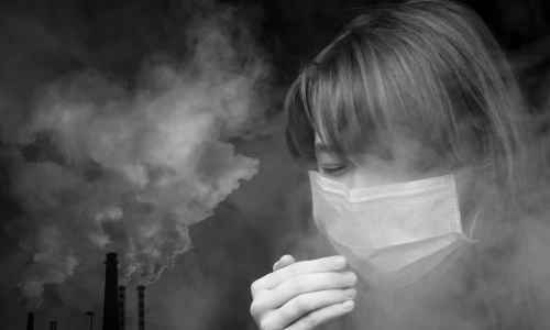 A close-up black and white shot of a masked woman, portraying those experiencing health issues from the chemical fire, considering participating in the BioLab class action lawsuit.