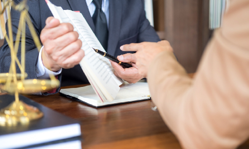 A defective product lawyer holding up notes for a client to see.