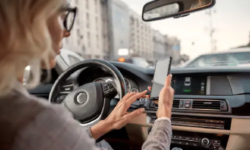 A driver distracted by her phone and texting while behind the wheel of her vehicle.