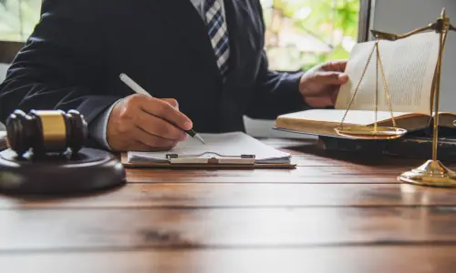 A workers' compensation attorney browsing a law book while building a case for a client.