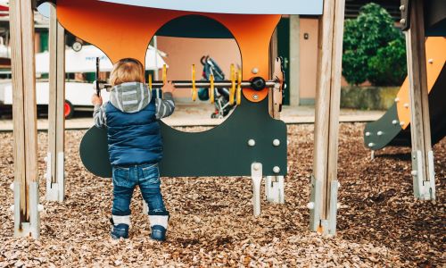 A child playing with equipment at a playground.