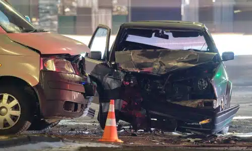 A T-bone accident at night between a car and a van.