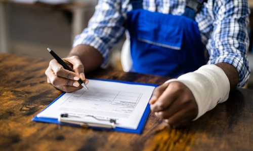 A blue collar worker with a cast on an arm filing an insurance claim.