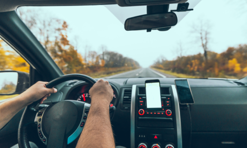 A rideshare driver on a rural road following instructions on his phone app.