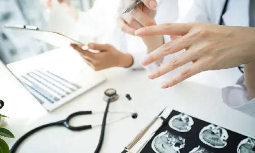 Medical professionals at a desk explaining to a patient the nature of their TBI.