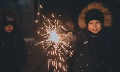 Children playing with fireworks at night.