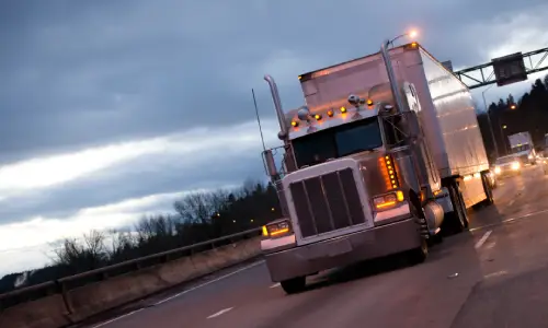 An early evening shot of a truck driving along a highway after rains.