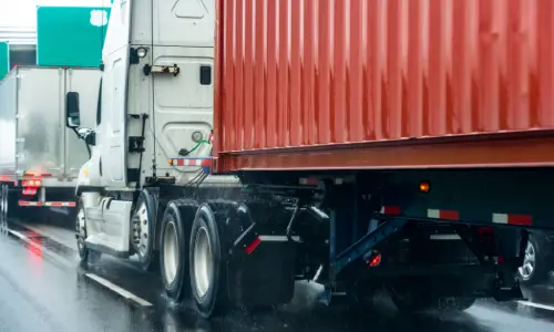 Trucks on a major highway lined up at a toll booth.