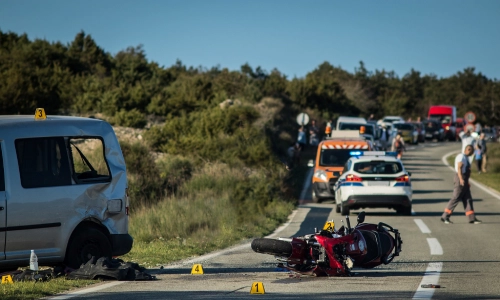 The scene of a motorcycle accident where a car was forced off the road.