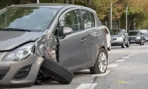 A rideshare vehicle with a damaged side after an accident on the road.