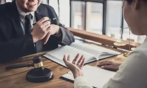 A man consulting a lawyer in an office to pursue a personal injury claim.