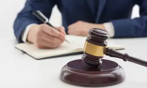 An attorney in a white room and seated at a desk while working.