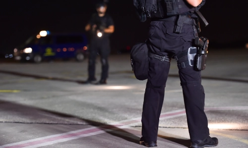 Two police officers securing the scene of a night time car accident.