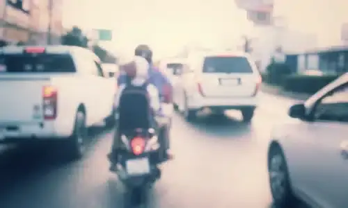A depth of field shot of a motorcycle attempting to lane split in heavy traffic.