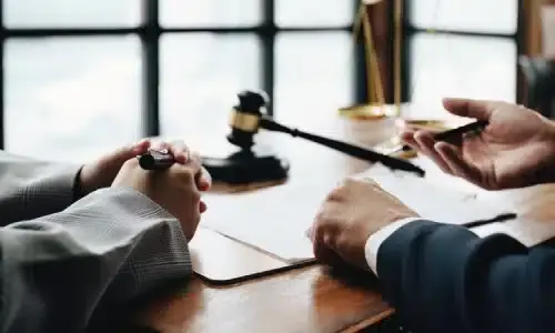 A wrongful death lawyer talking with a client in his office.