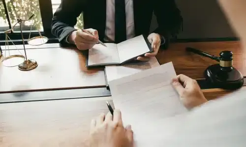 A lawyer going over documentation for a wrongful death claim together with a client.