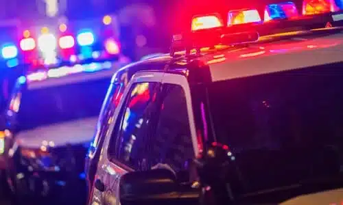 Lights of police vehicles during a night time chase with a suspect.