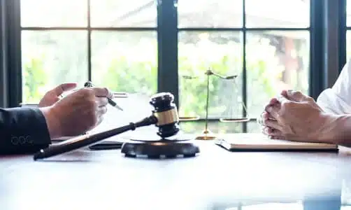 A rollover accident lawyer offering legal advice to a client seated at his desk.
